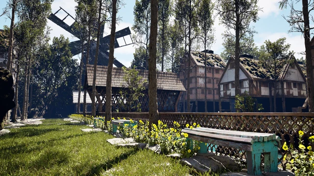 A sunlit medieval village scene features a large wooden windmill with four blades standing tall amidst a grove of slender trees. Nearby, rustic timber-framed houses with moss-covered roofs and a covered wooden walkway are visible. A wooden lattice fence runs along a grassy area separating the viewer from the structures. Bright yellow flowers bloom in a garden bed alongside a weathered wooden bench with turquoise paint. The atmosphere is peaceful and bright, with clear blue skies and dappled sunlight filtering through the trees.